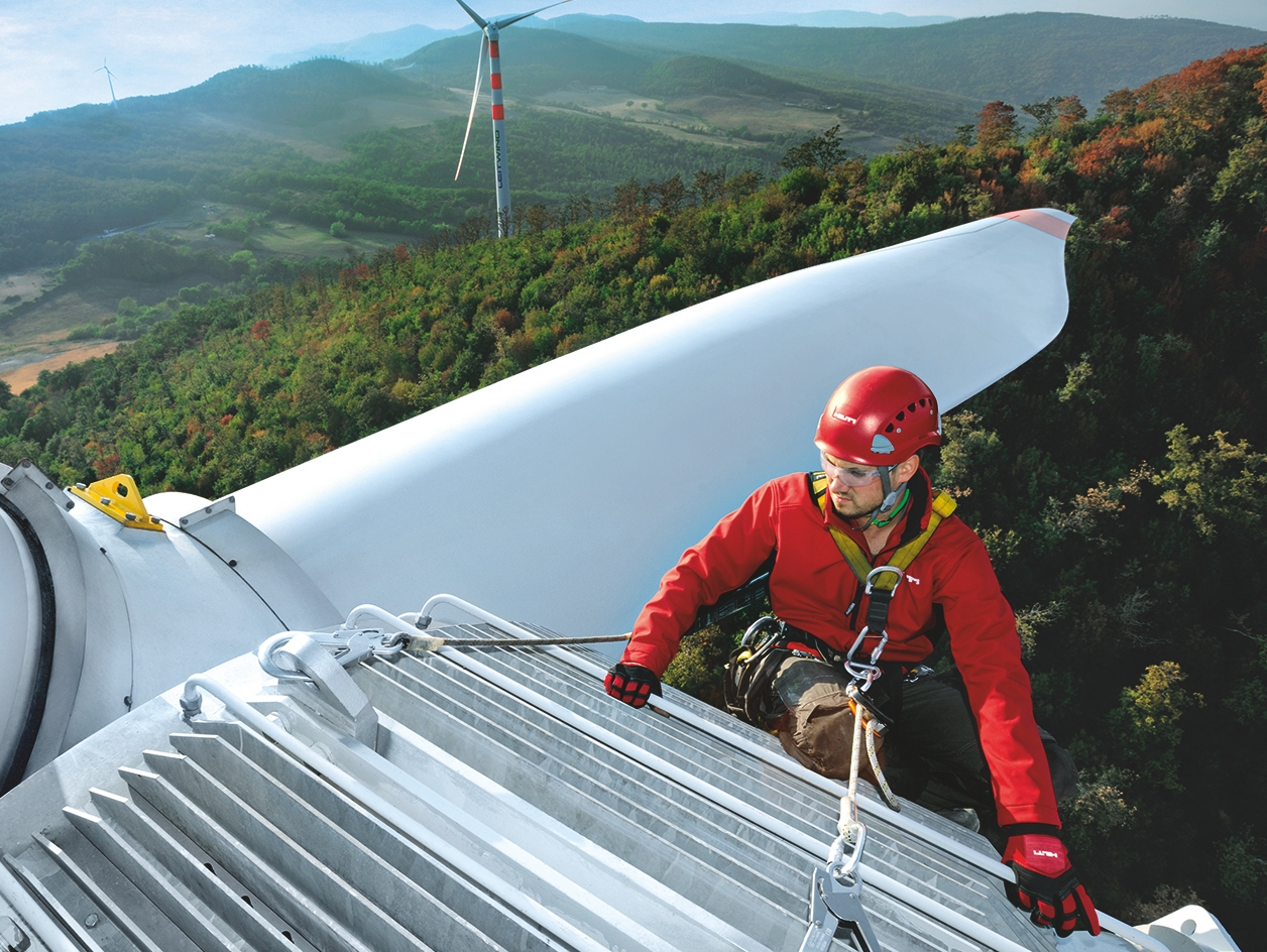 Ein in Hilti-Ausrüstung gekleideter Spezialist führt Arbeiten an einer Windmühle durch