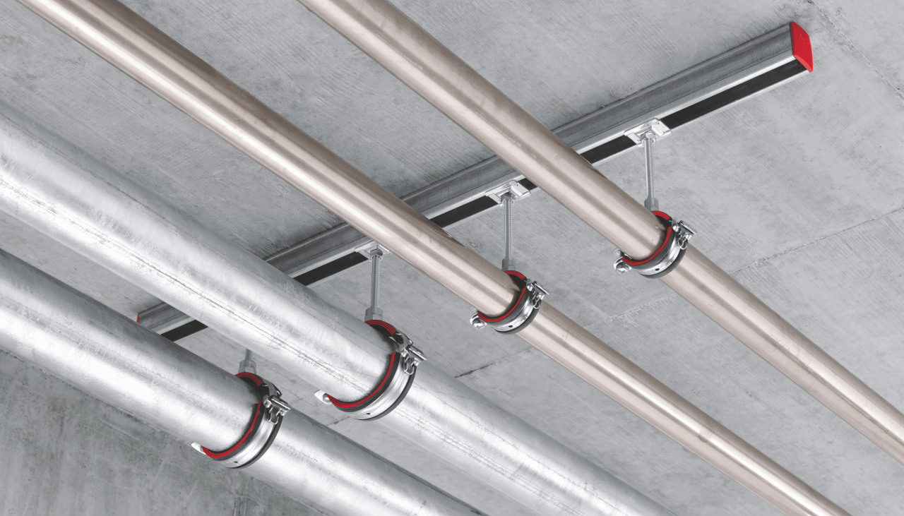 Systemlösung zur Mehrfachrohrbefestigung, die aus dem Schienensystem MM, dem Schraubanker HUS3-P und den Rohrschellen MP-U-I besteht.