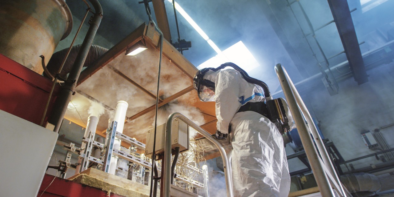 Mitarbeiter im Schutzanzug arbeitet in einem Labor