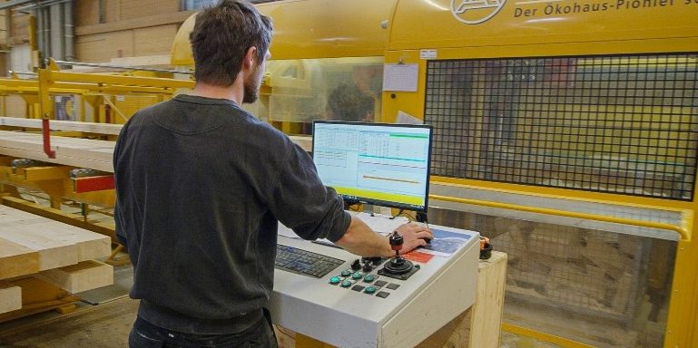 Arbeiter im Werk beim maschinellen Abbund