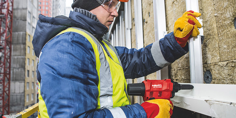 Arbeiter verschraubt eine Fassadenunterkonstruktion