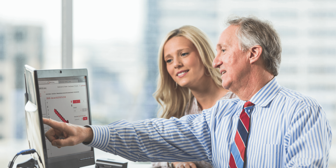 BIM/CAD Bibliothek. Ein Mitarbeiter und eine Mitarbeiterin kommunizieren im Büro.