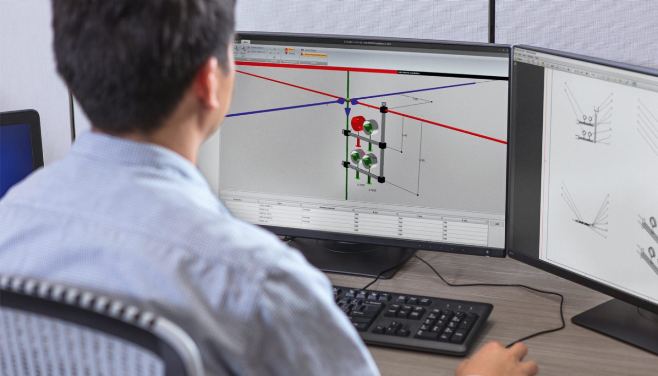 Mann am PC plant modulare Schienensysteme