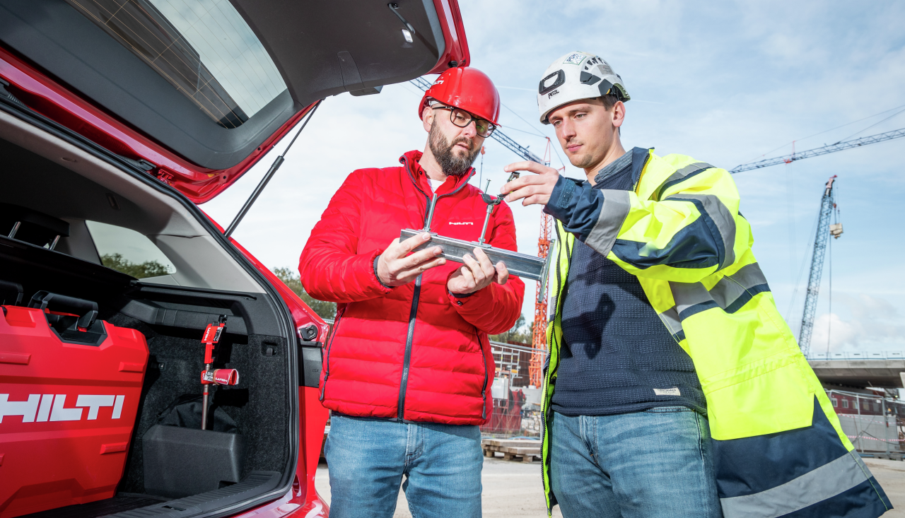 Verkaufsberater im Gespräch mit Kunden am Kofferraum